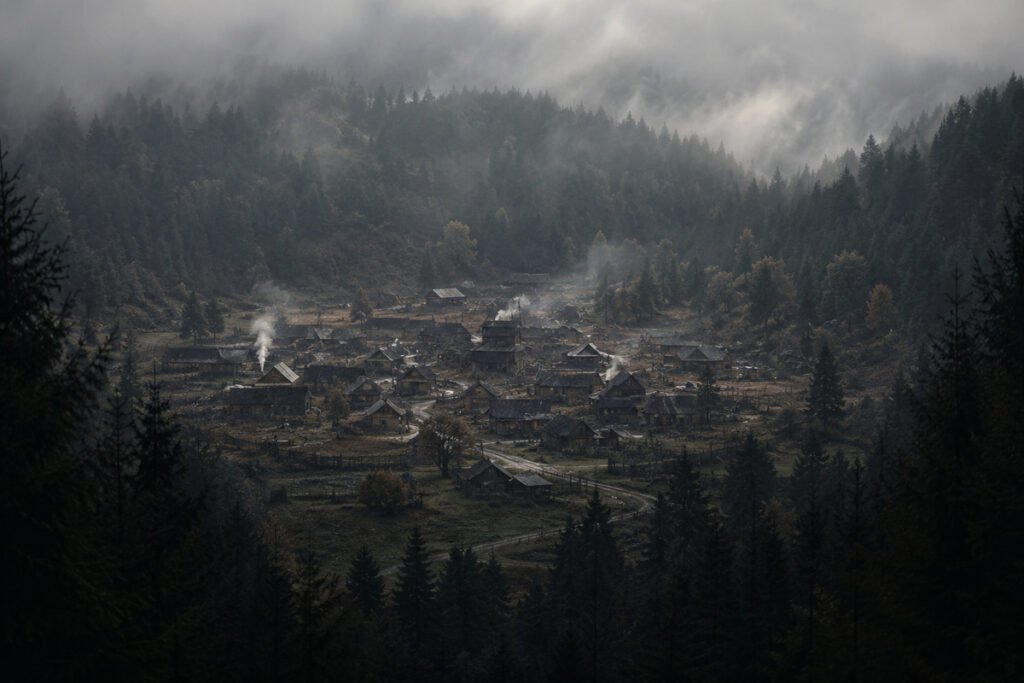 Dark isolated village surrounded by forest and fog, symbolizing a thought experiment about what happens when only narcissistic people exist in one closed social environment.
